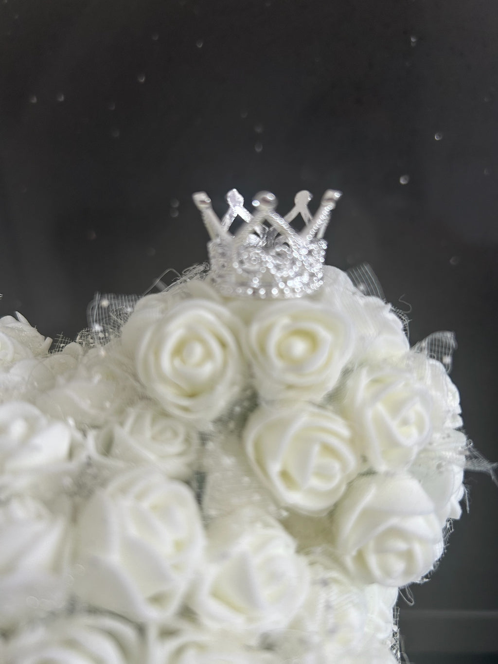 Hartes Handmade white foam rose teddy bear featuring a sparkling silver crown detail on a dark background