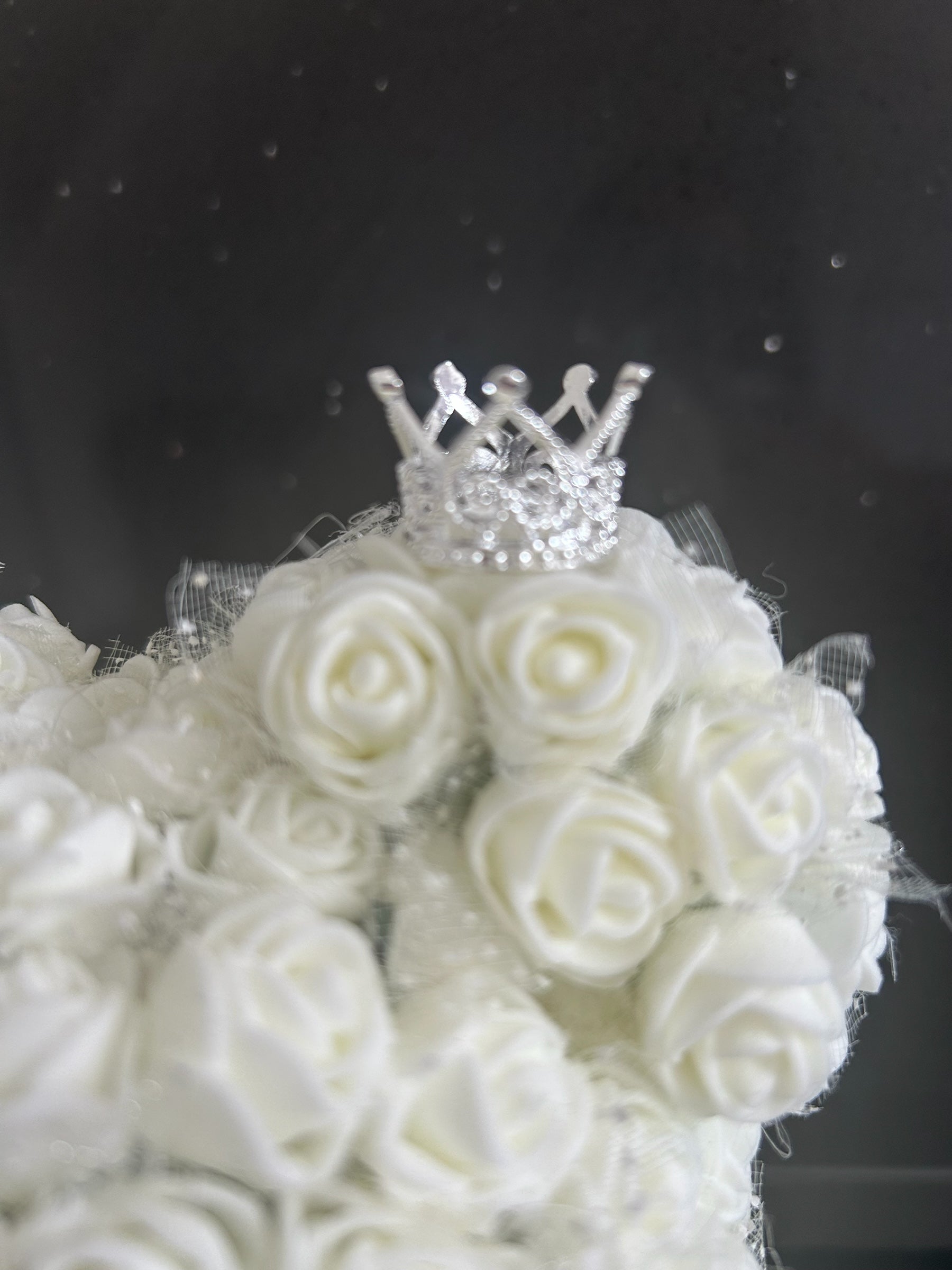 Hartes Handmade white foam rose teddy bear featuring a sparkling silver crown detail on a dark background